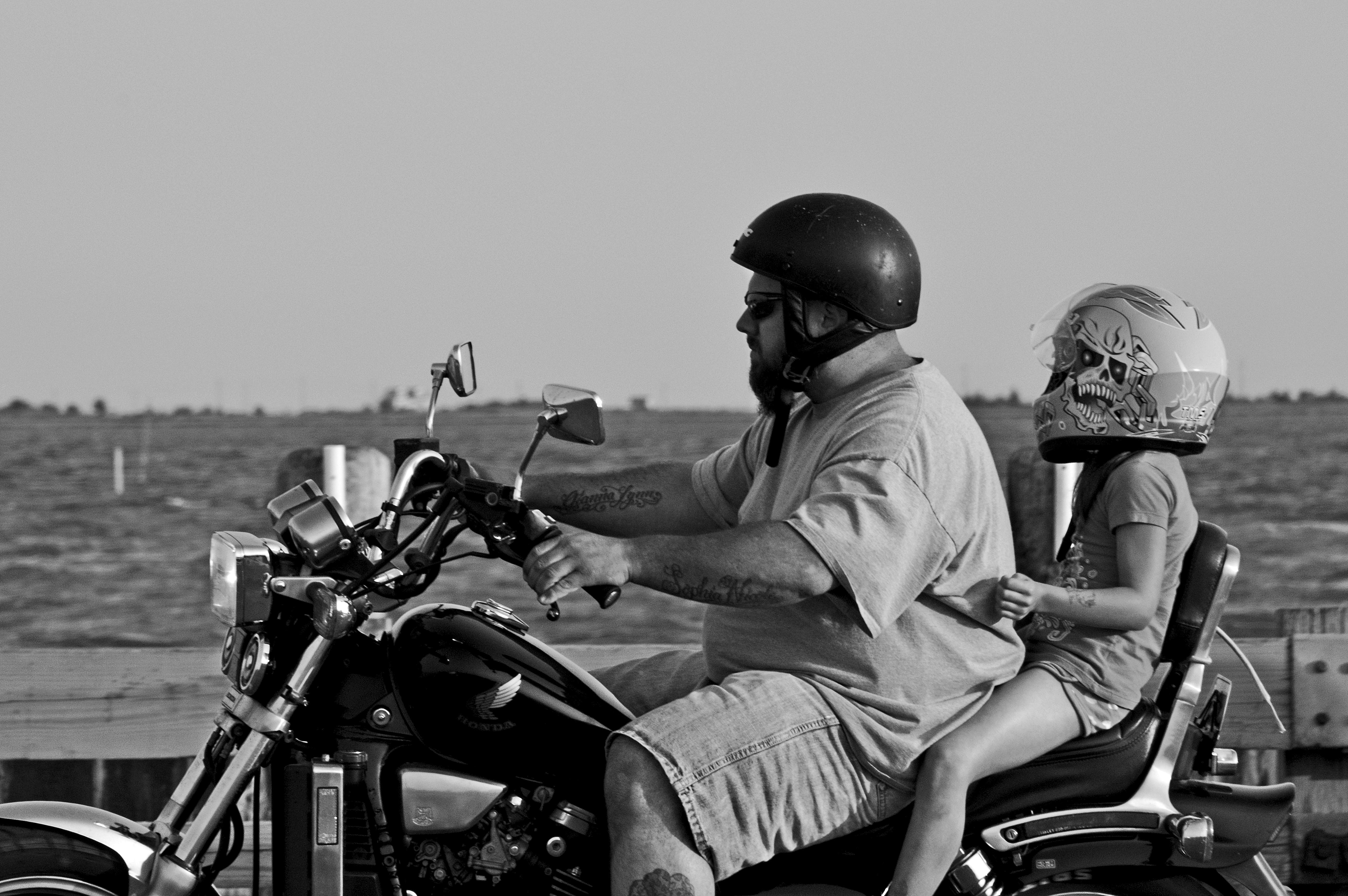 kid riding motorcycle with dad