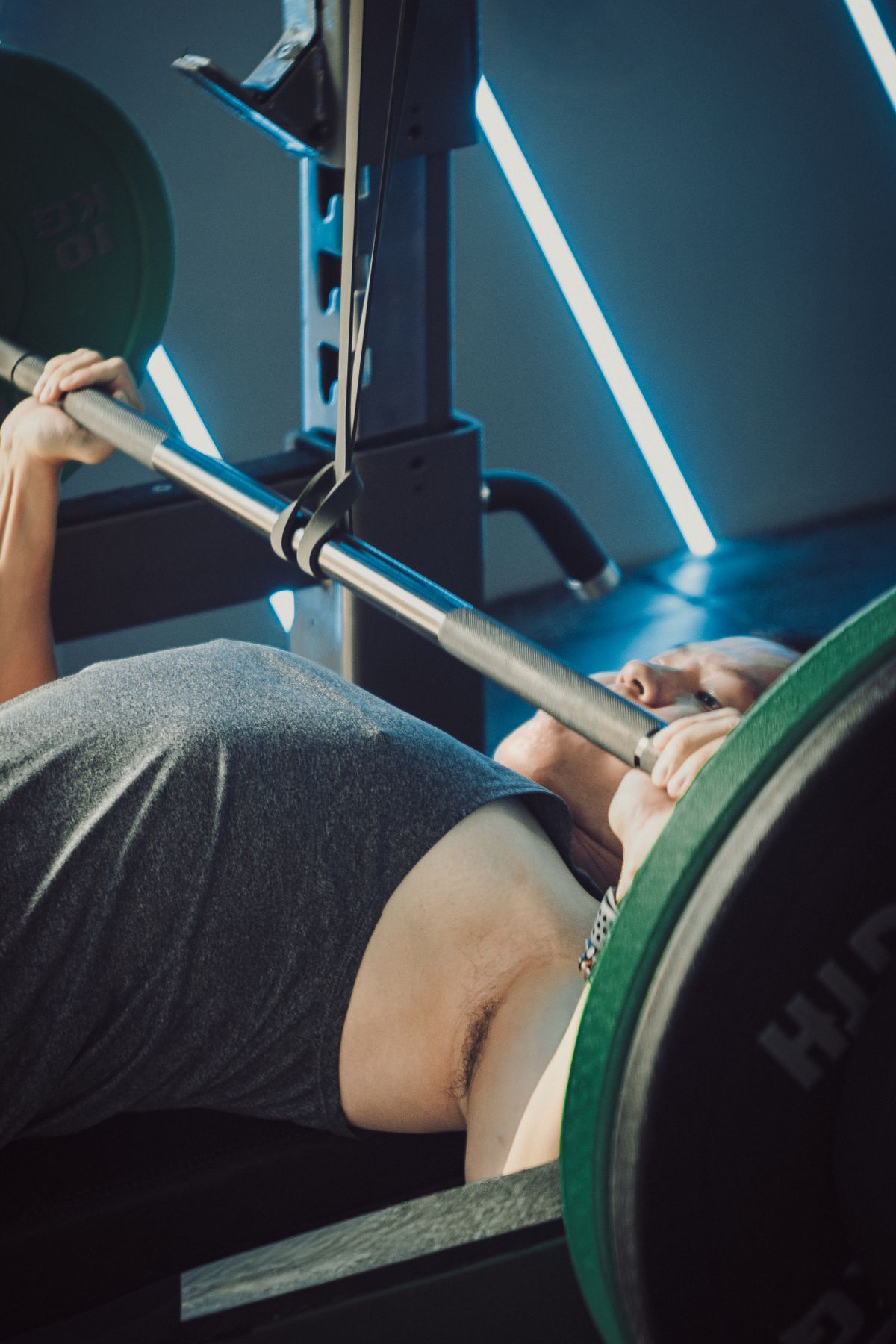 Man performing a bench press in a modern strength training gym