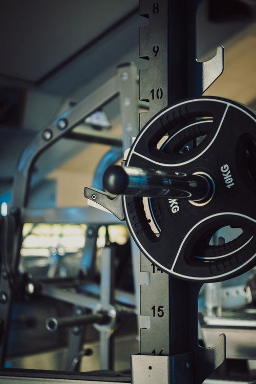 Free A detailed view of a 10kg barbell plate on a Smith Machine in a gym setting. Stock Photo