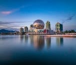 未来派城市景观中，现代摩天大楼与中间的球形镜建筑，依傍平静的大海，映衬着晴朗的天空