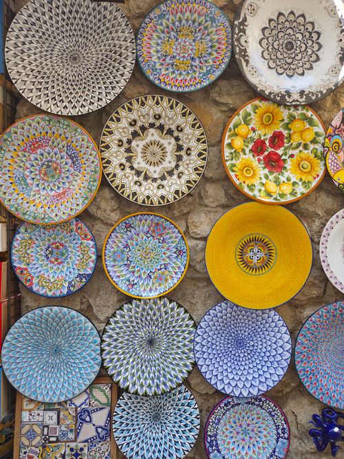Free Vibrant ceramic plates displayed on a stone wall in Campania, Italy. Stock Photo