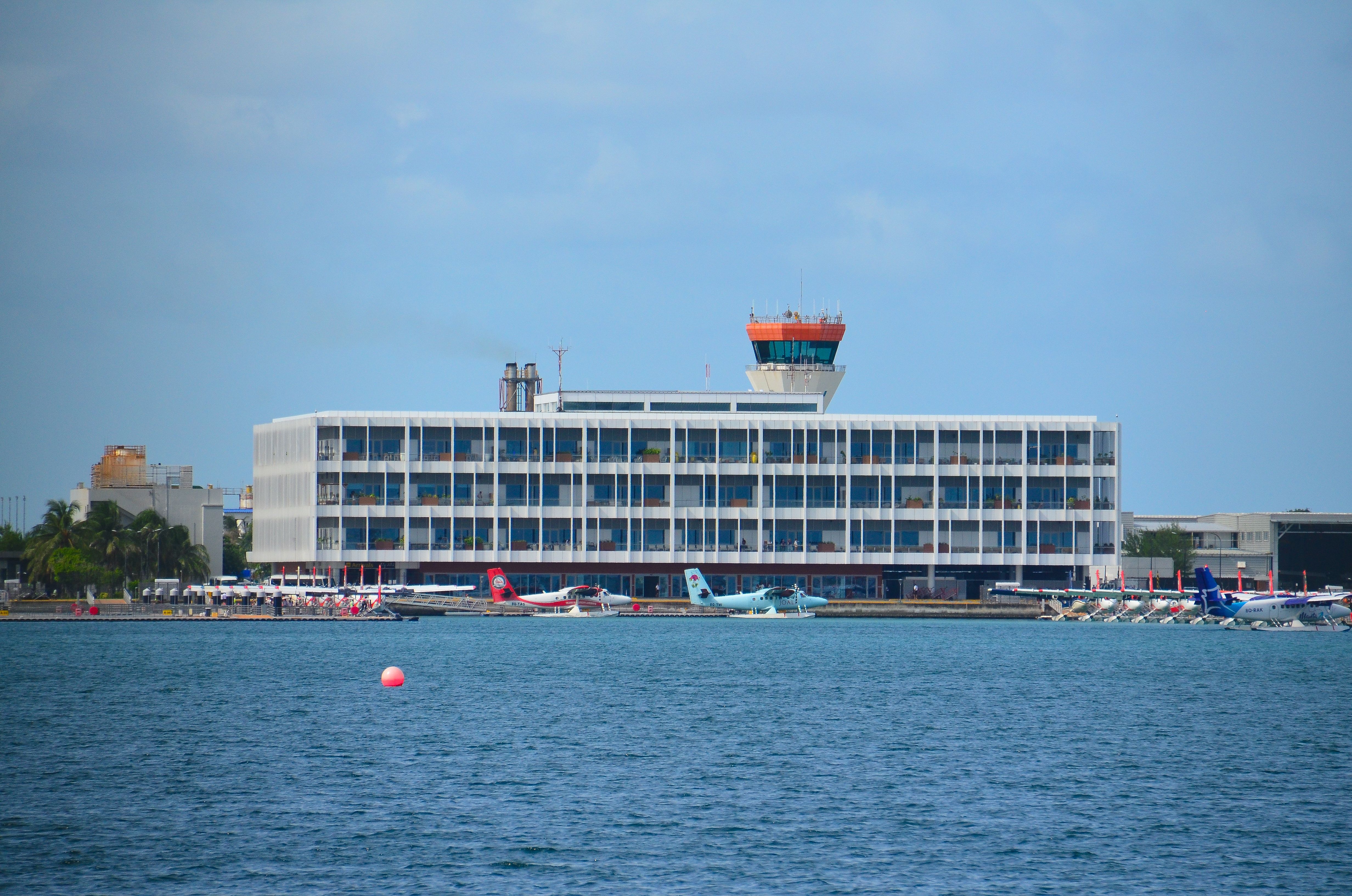 Seaplanes docked at a terminal in Maldives under a clear blue sky, highlighting island transport.