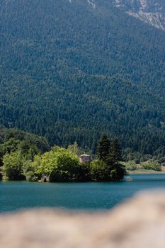 Tranquil scene of Lake Doxa surrounded by lush forest and mountains, Greece.