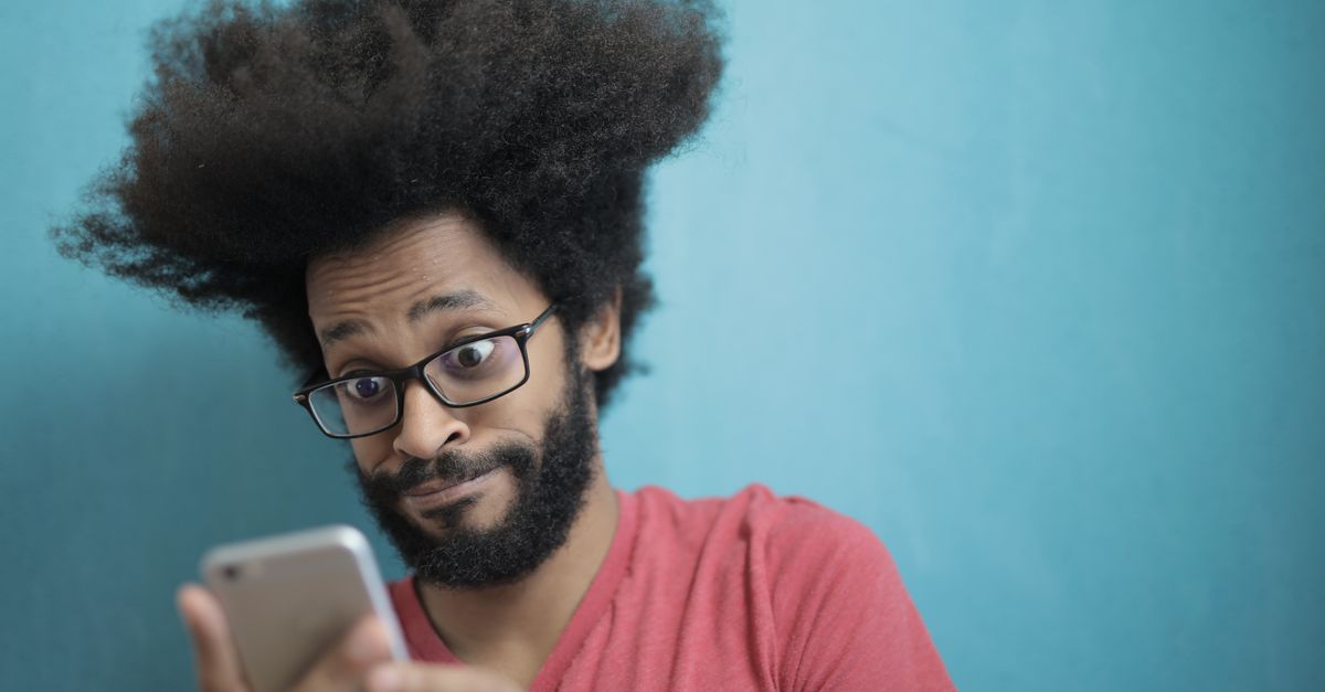 A person looking shocked while looking at their phone showing a list of subscriptions