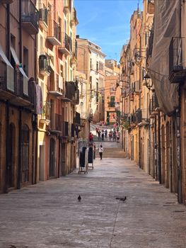 Explore the vibrant and historic streets of Tarragona with colorful architecture and lively atmosphere.