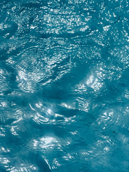 Free Close-up of sunlight reflecting on a textured blue water surface. Ideal for backgrounds. Stock Photo