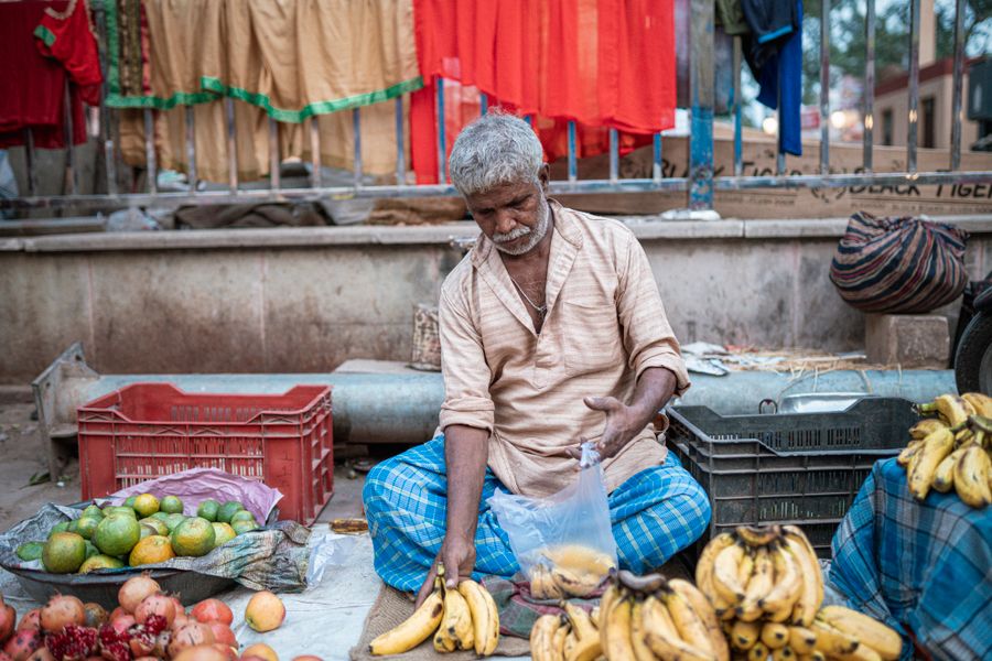 A fruit vendor arranges bananas at a street market in Varanasi, India.