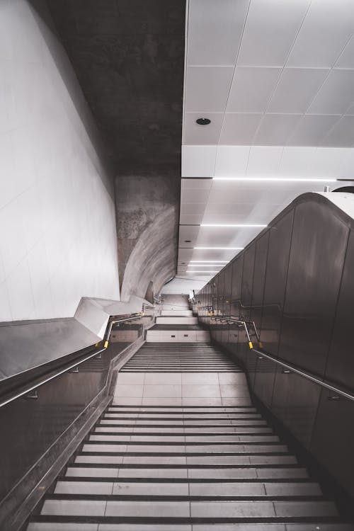 From above of modern stairway covered with tile and metal railings leading to underground station