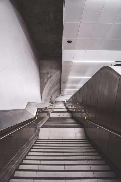 Free From above of modern stairway covered with tile and metal railings leading to underground station Stock Photo