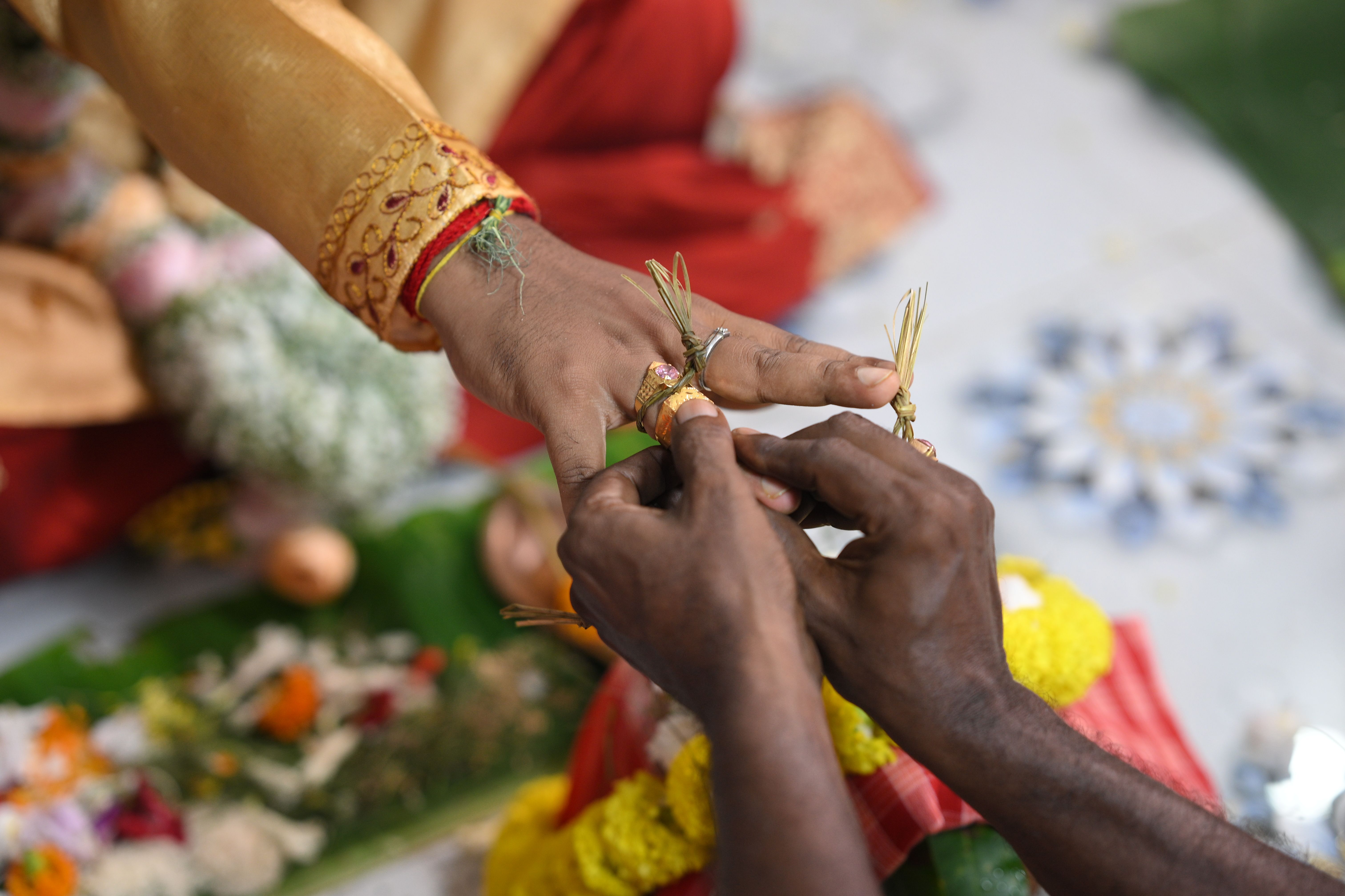 Close-up of a woman in traditional attire holding vibrant flower garlands, showcasing Indian culture.