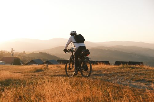 Free Cyclist explores scenic mountain path in Poland during sunset, capturing nature's beauty. Stock Photo