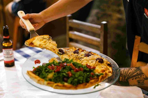 Person Holding A Plate With Pizza