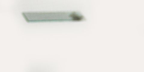 Blood vacutainer with sample and slide on a white background for medical testing.