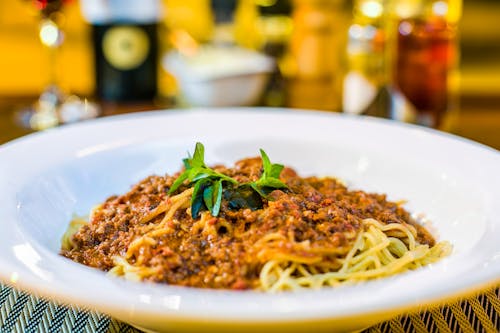 Pasta With Green Leaf On Top On White Ceramic Plate