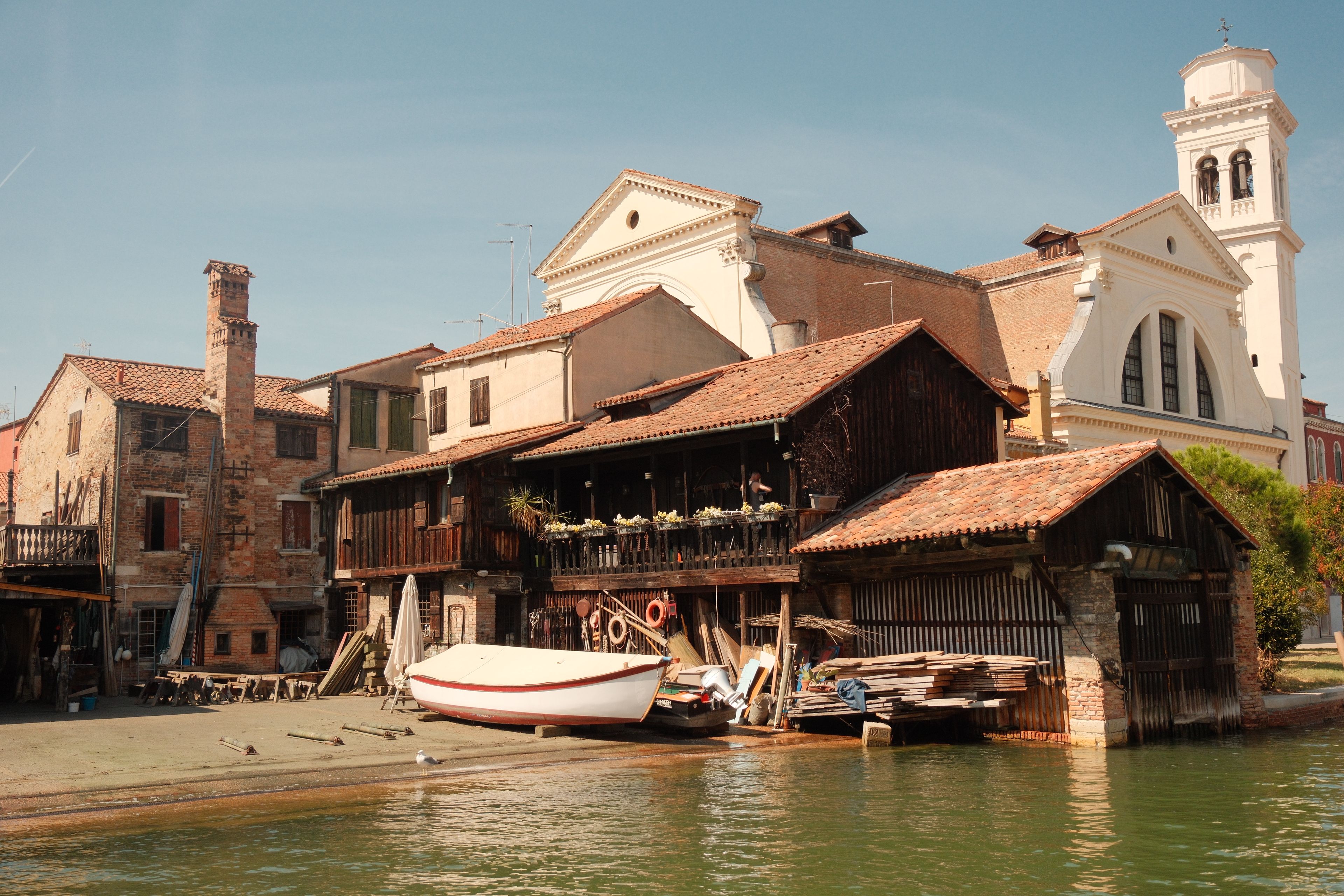 Rustic buildings by the water in Venice with boats and classic architecture.