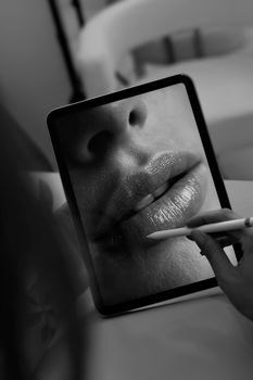 Close-up monochrome image of lips on a digital tablet, emphasizing texture and detail.