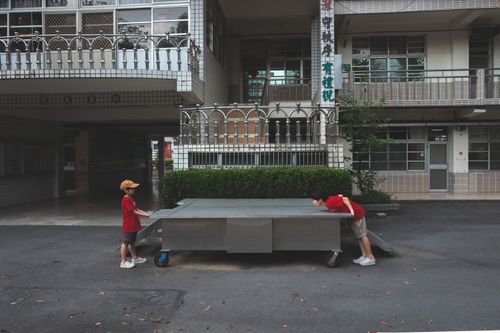 Free Two children interacting with a mobile platform in an outdoor setting near a building. Stock Photo