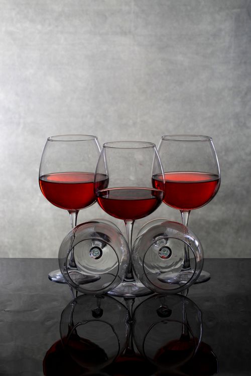 Free A stylish composition of red wine glasses creates an artistic symmetry on a reflective surface, ideal for culinary themes. Stock Photo