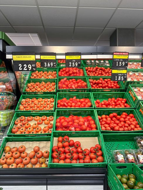 Colorful display of tomatoes in a grocery store with prices shown per kilogram. Colorful display of tomatoes in a grocery store with prices shown per kilogram.