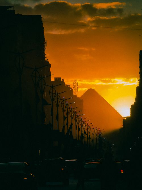 Free A stunning sunset view of Cairo's skyline with the Great Pyramid in the background. Stock Photo
