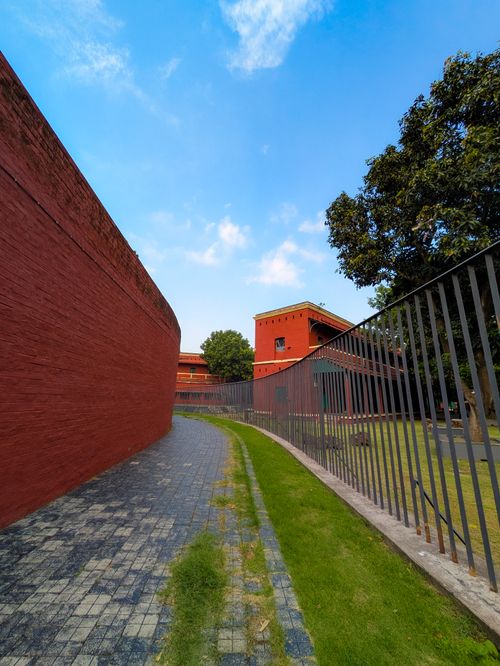 Free A striking modern building with red brick walls under a bright blue sky. Stock Photo