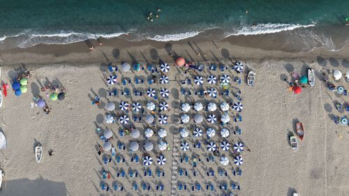 Free Aerial view of a beach in Calabria, Italy, with striped umbrellas and sun loungers, capturing summer vibes. Stock Photo