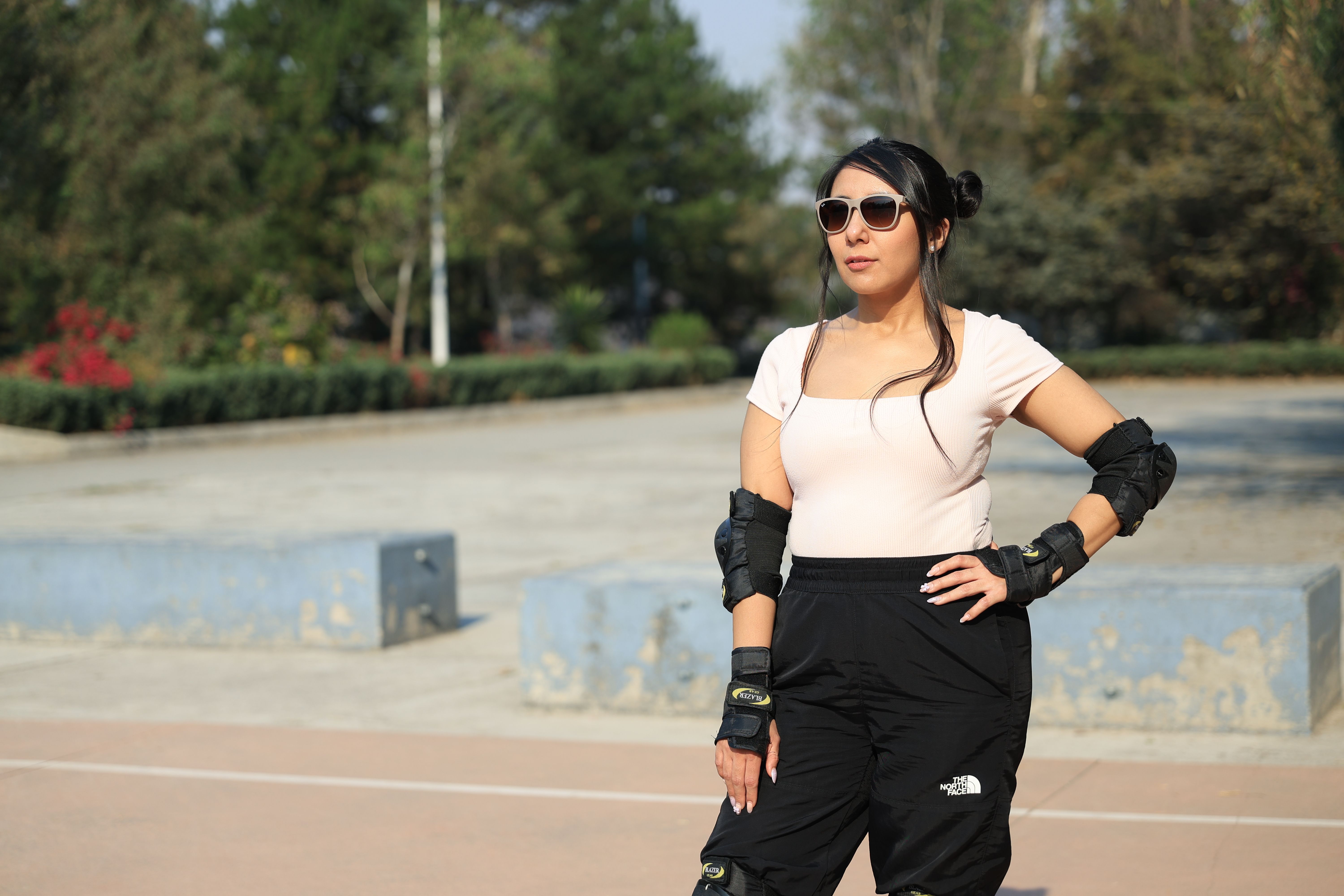 Woman wearing protective gear and sunglasses, enjoying a sunny day outdoors.