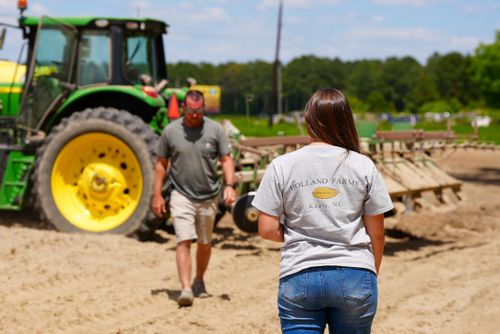 Free Two farm workers at Holland Farms with tractor equipment on a bright sunny day. Stock Photo