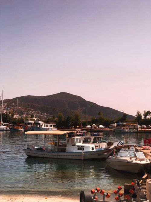 Free Idyllic view of Antalya harbor featuring boats and a mountainous backdrop under the clear sky. Stock Photo