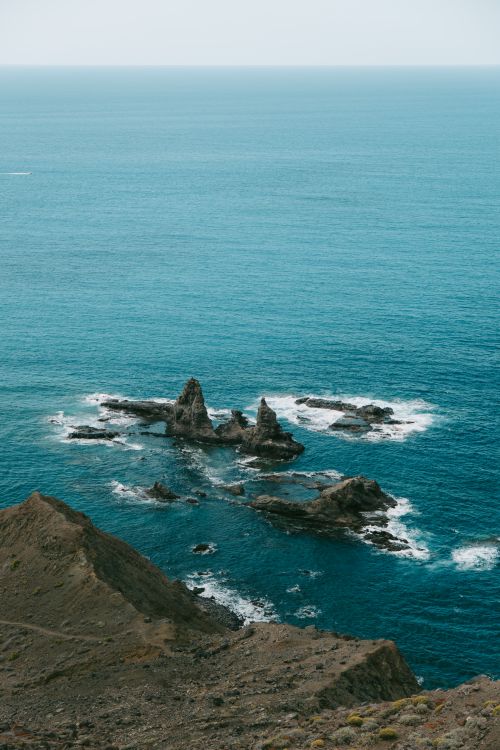 Free Discover the stunning volcanic cliffs and blue waters of Arguamul's rocky coastline in the Canary Islands. Stock Photo