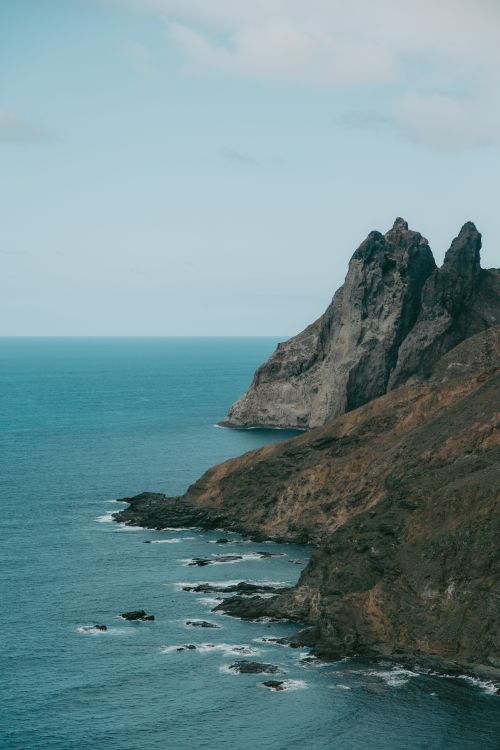 Free Explore the rugged volcanic coastline of Arguamul, Spain with dramatic cliffs and turquoise waters. Stock Photo