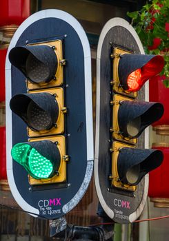 Close-up of dual traffic lights in Mexico City, showcasing a vibrant urban setting with red and green signals.