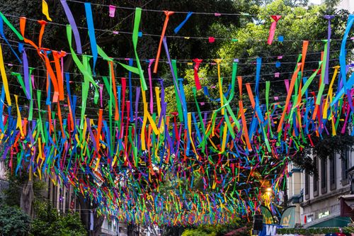 Free Colorful ribbons adorn a festive street scene in Mexico, showcasing vibrant cultural decorations. Stock Photo