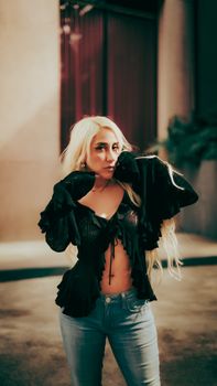 Confident woman posing in trendy outfit outdoors at night, showcasing urban fashion.