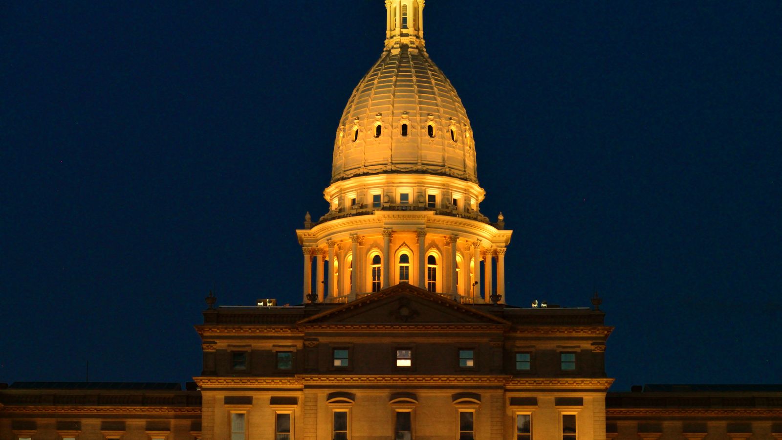Night view of the beautifully lit Michigan State Capitol in Lansing, highlighting its architectural splendor.