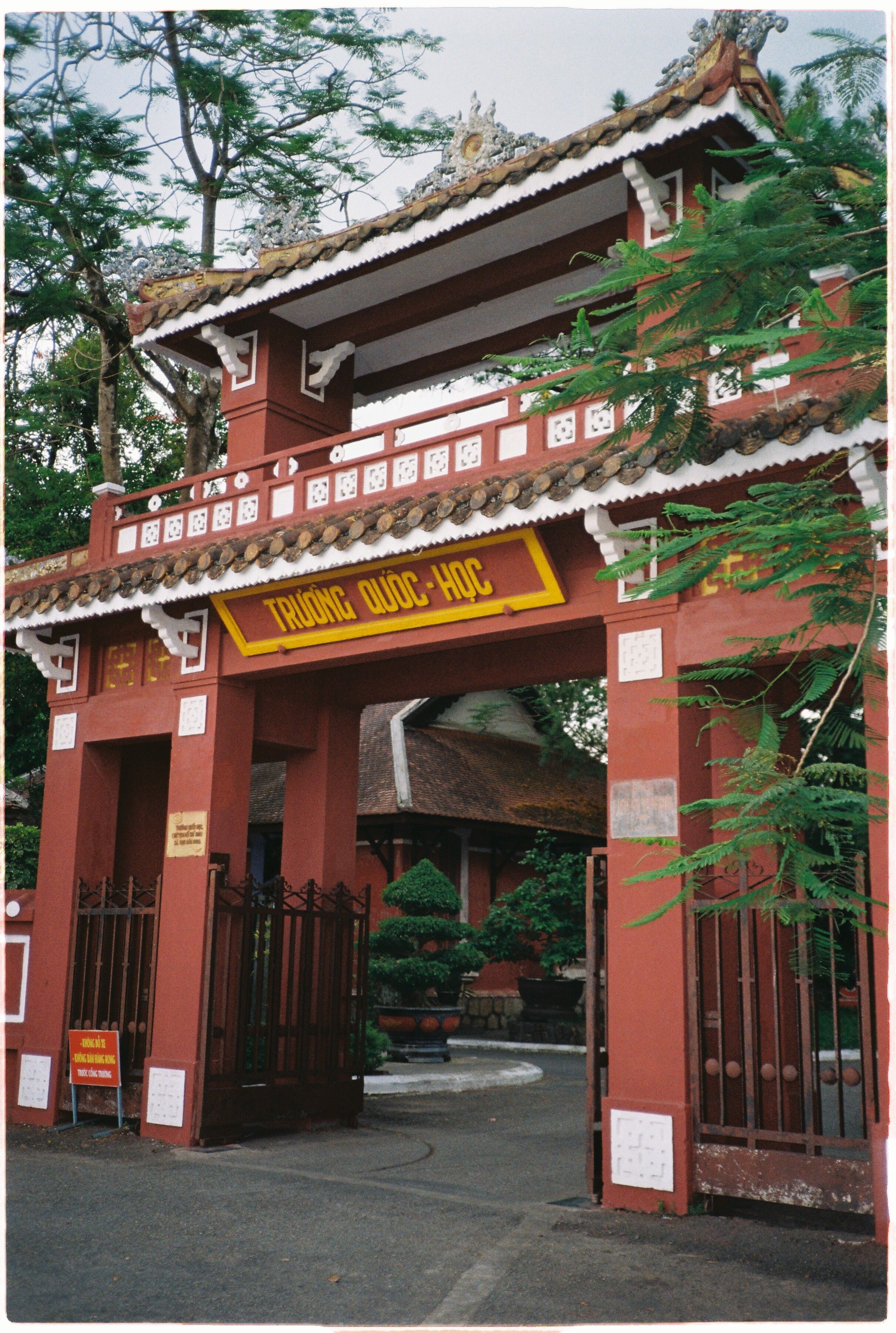 Explore the historical gate of Quốc Học High School, Hue, Vietnam, showcasing traditional architecture.