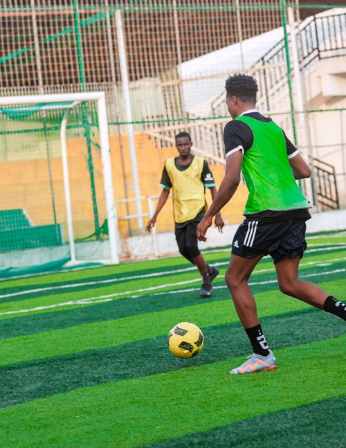 Free Two young men playing soccer on a green turf field during outdoor practice. Stock Photo