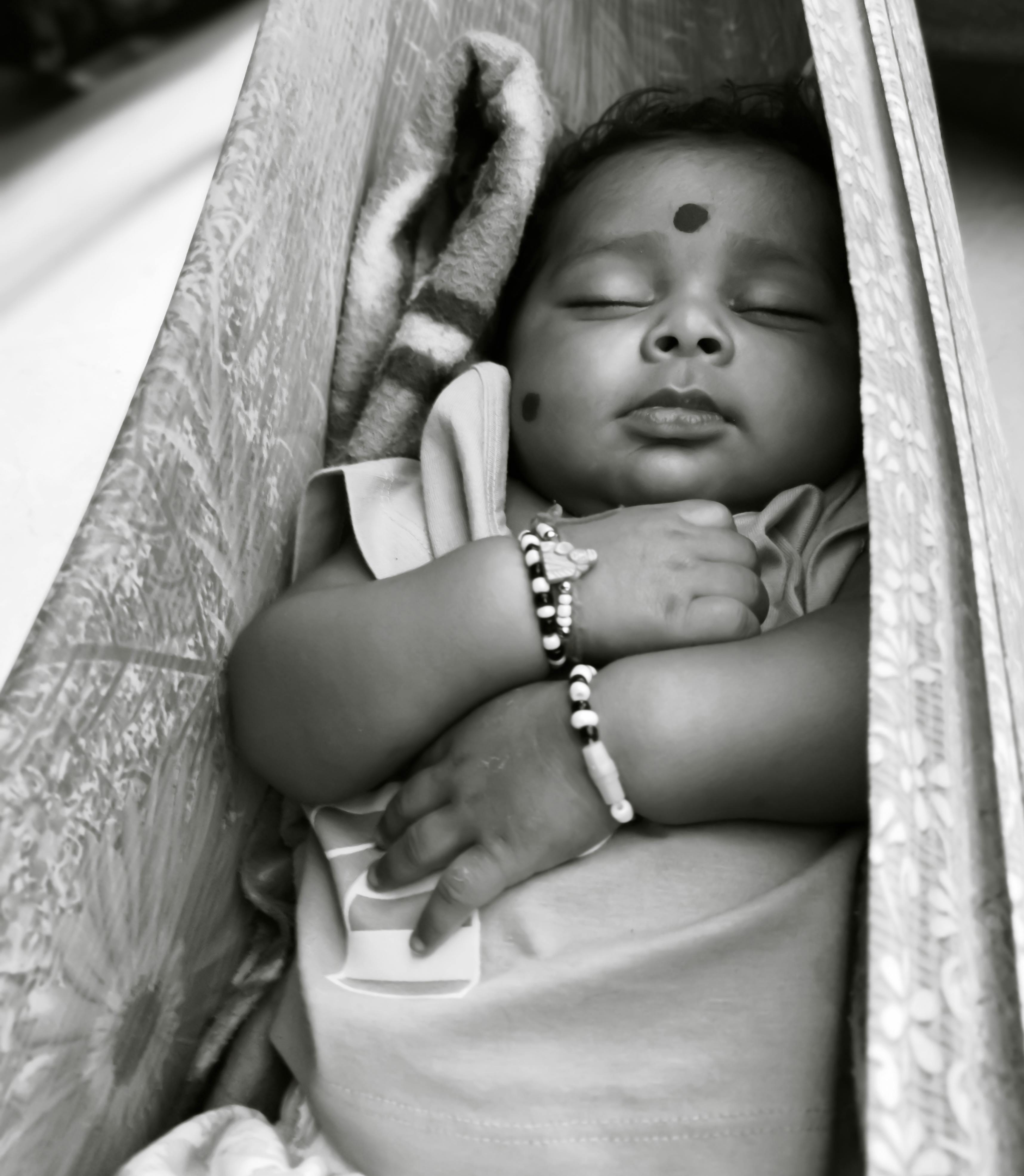 grayscale photo of baby lying on hammock