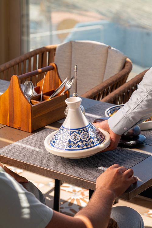 Free An elegant indoor dining setup featuring a Moroccan tagine pot on a table, showcasing cultural cuisine. Stock Photo