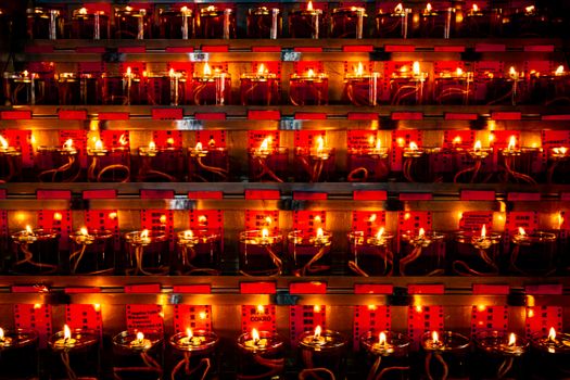 A striking display of candle lanterns glowing warmly in a Jakarta temple, creating a serene spiritual atmosphere.