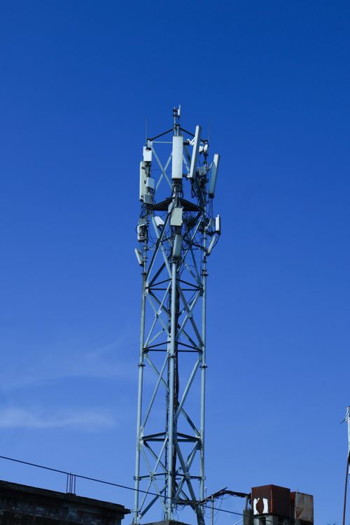 Free Tall telecommunications tower under a vibrant blue sky, symbolizing connectivity. Stock Photo