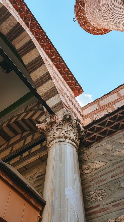 Free A detailed look at an ornate pillar amidst historical stonework under a clear blue sky. Stock Photo