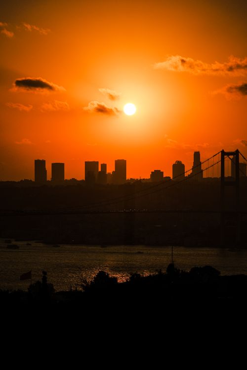 Free Stunning sunset over the Bosphorus with Istanbul's skyline, showcasing a vibrant orange sky. Stock Photo