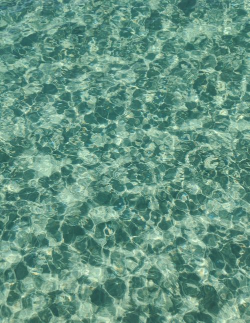 Free A mesmerizing view of clear aqua blue water with natural patterns and reflections. Stock Photo