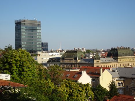 View of Zagreb's skyline showcasing modern skyscrapers and historic buildings under a clear blue sky.