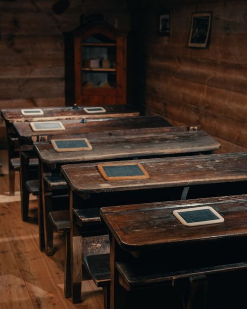 Free Old wooden desks in a rustic classroom setting showcase historical education methods. Stock Photo