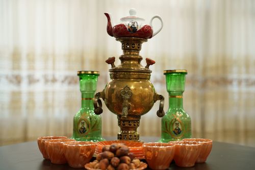 Free Elegant Persian samovar with teapot, green jars, and tea cups on display. Stock Photo