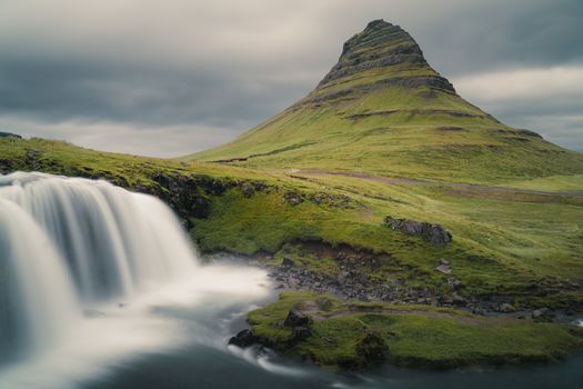 Scenic view of Kirkjufell mountain and waterfall, Iceland's iconic landscape.