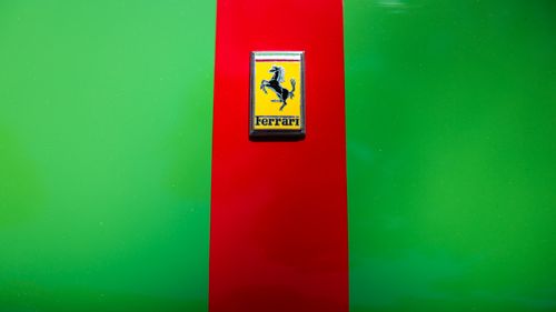 Free Ferrari logo on a red and green background, emphasizing the brand's iconic design. Stock Photo