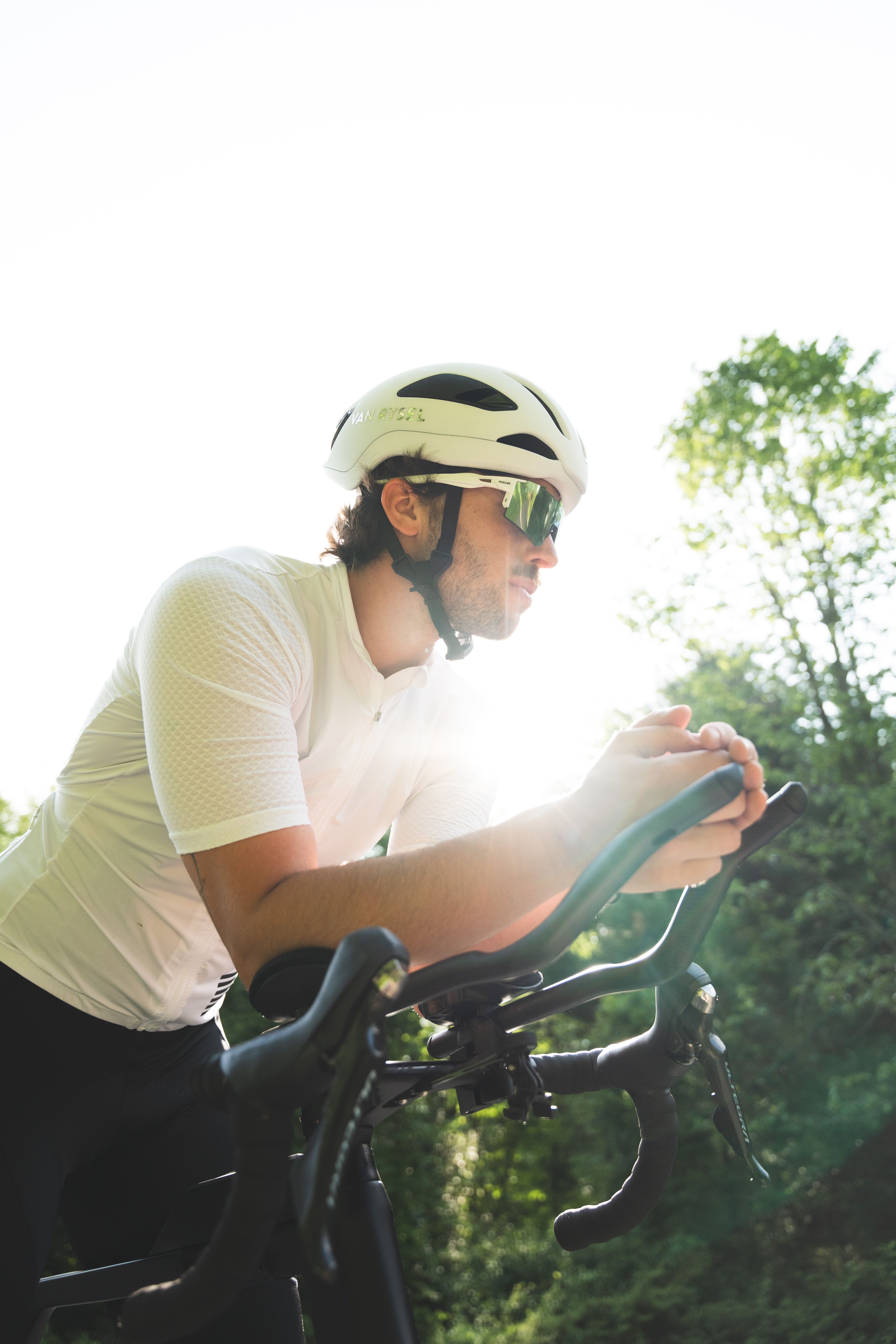 A cyclist with a helmet rides a bike outdoors on a sunny day, capturing the essence of outdoor sports.